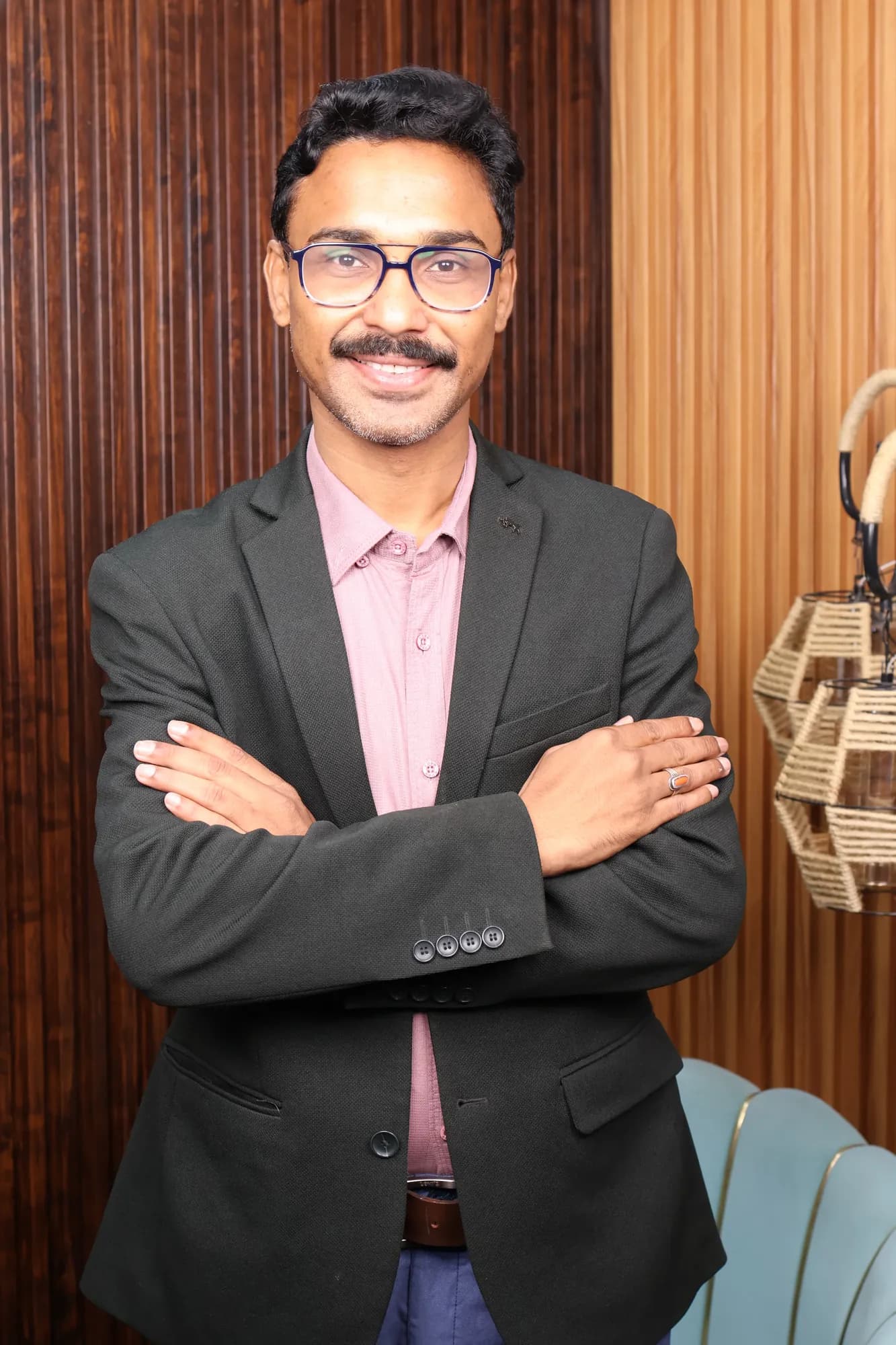 Adarshh Panndey standing with arms crossed in a studio